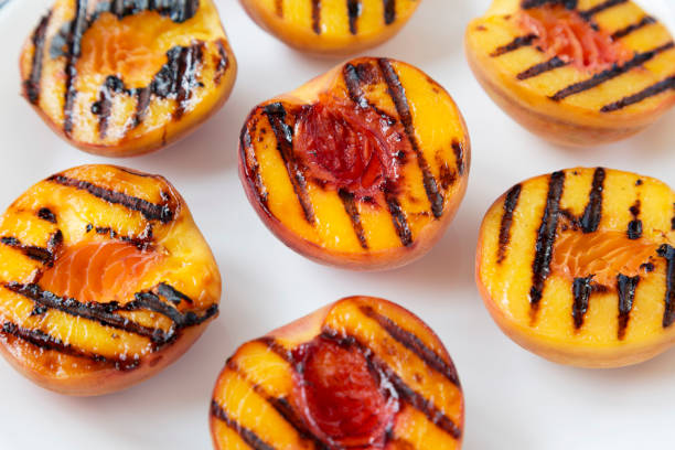 istock Homemade grilled peaches on a white plate, low angle view. Close-up. 1167513746