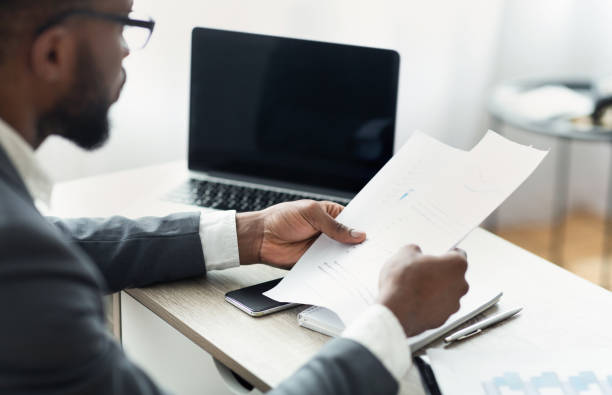 istock African entrepreneur reading financial reports, working in modern office 1167513816