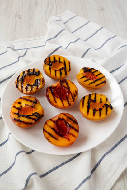 istock Homemade grilled peaches on a white plate, low angle view. Closeup. 1167513824