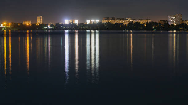 istock Skyline panorama of night city with lights reflection over water 1167513985