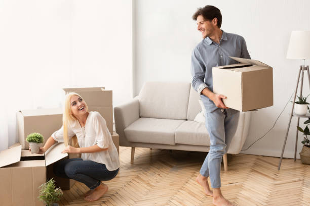 istock Young Married Couple Unpacking Moving Boxes In New House 1167514286