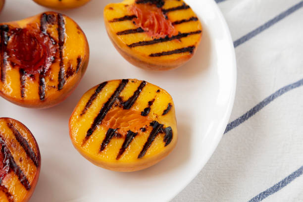 istock Homemade grilled peaches on a white plate, low angle view. Close-up. 1167514815