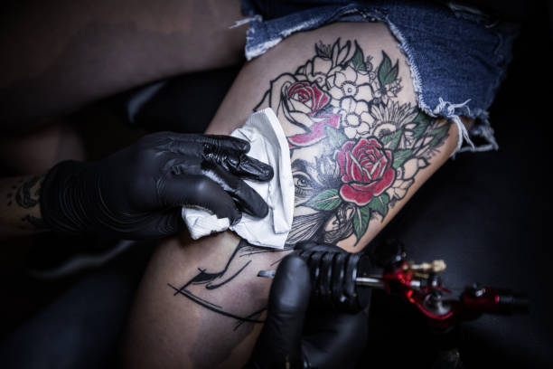 istock Tattoo artist making tattoo on customer's leg 1167517771