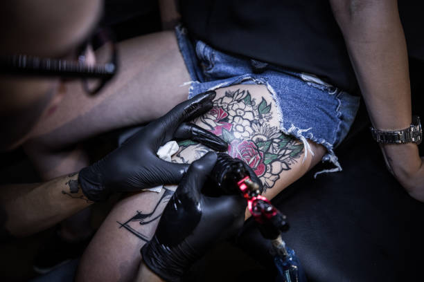 istock Tattoo artist making tattoo on customer's leg 1167518970