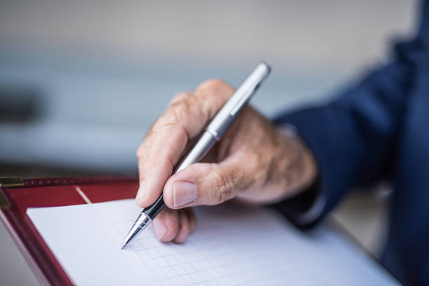 istock Senior businessman writing a business strategy in notebook. 1167519545