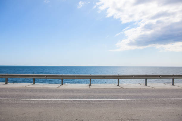 istock highway with fencing along the sea 1167520121