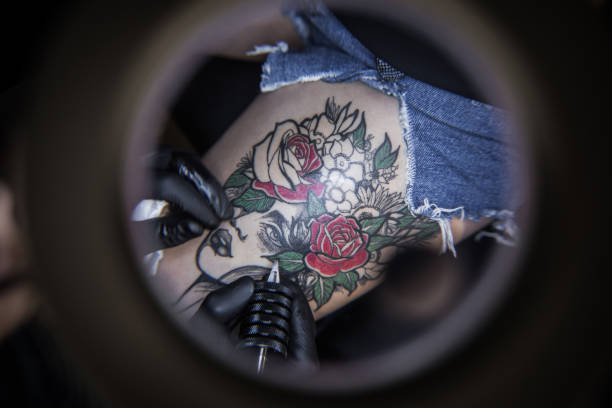 istock Tattoo artist making tattoo on customer's leg 1167520135