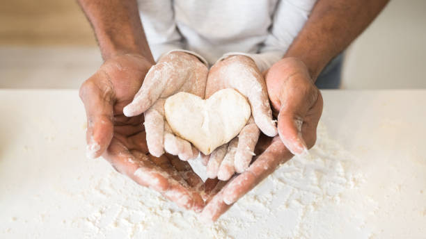 istock Afro man hands holding child hands with heart shaped pastry 1167521161