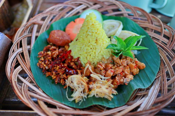 istock Nasi Kuning. Javanese turmeric rice with assorted side dishes 1167522996