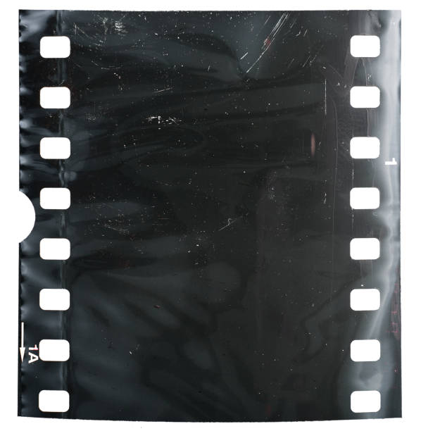 Real and original 35mm or 135 film material or photo frame in foil on white background, 35mm filmstrip with dust real 35mm film material in foil, macro photo, no scan 16mm film motion picture camera photos stock pictures, royalty-free photos & images