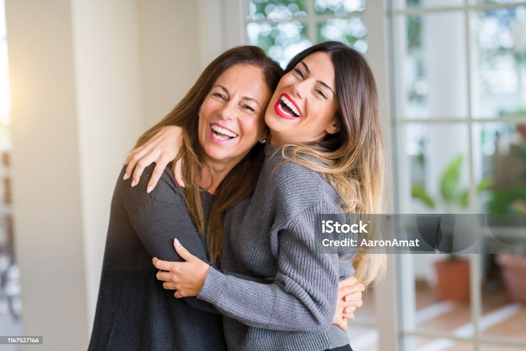 Beautiful family of mother and daughter together, hugging and kissing at home Mother Stock Photo