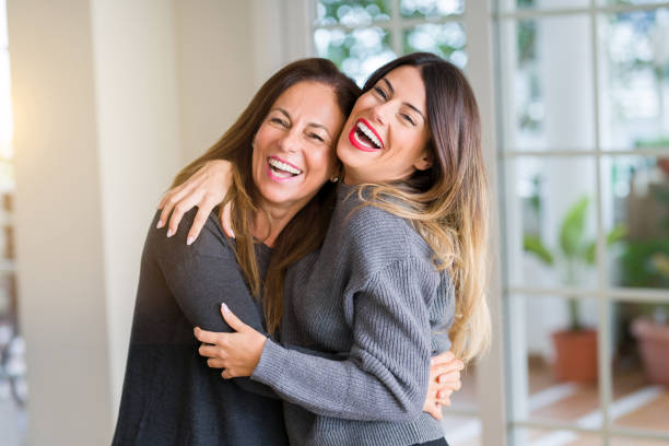 família bonita da matriz e da filha junto, abraçando e beijando em casa - family adult portrait cheerful - fotografias e filmes do acervo