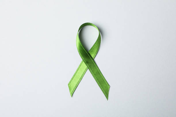 istock Green awareness ribbon on grey background, space for text 1167527301