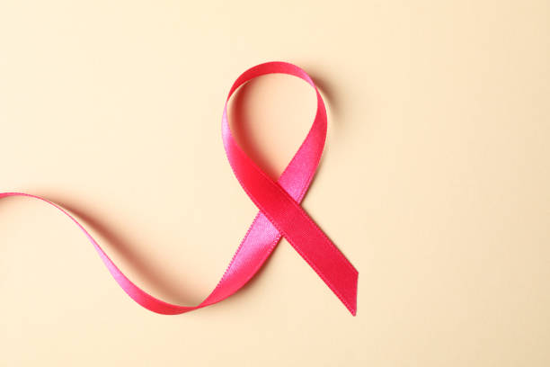 istock Pink awareness ribbon on color background, space for text 1167528697