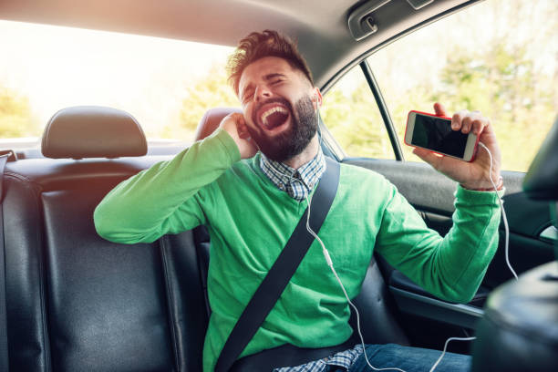 joven escuchando música mientras viaja - seat belt audio fotografías e imágenes de stock