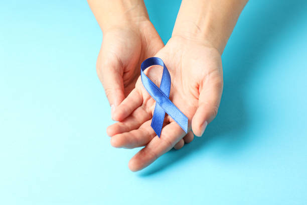istock Female hands hold blue awareness ribbon on color background, space for text 1167530108