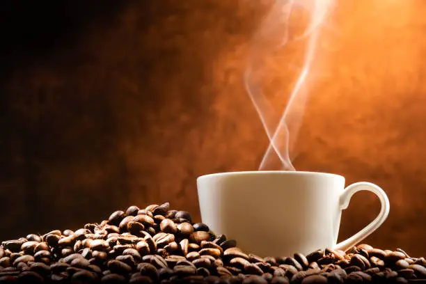 Photo of Cup of hot coffee with coffee beans