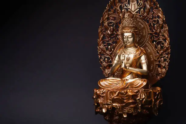 Statue of Bodhisattva Guan Yin (Avalokiteshvara) made of bronze sitting in the lotus position, having put hands in knowledge-mudra.