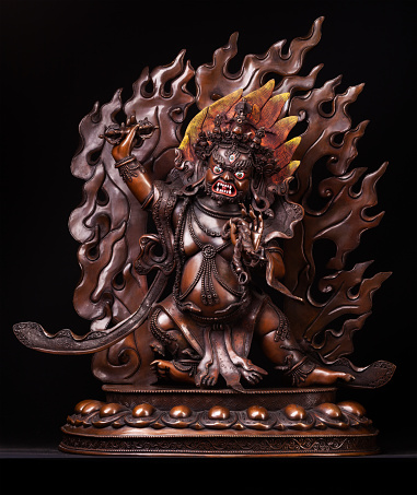 Vadzrapani is Buddha's defender and a symbol of its power. Bodhisattva in an angry image with a dorje in one hand and a lasso in another. The figure made of bronze, isolated on a black background.