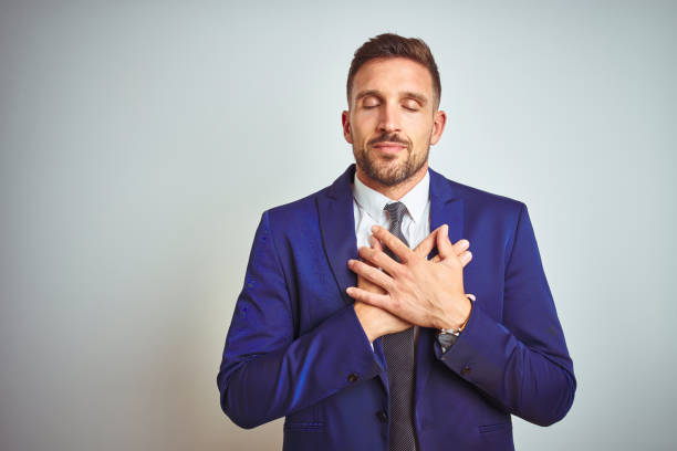 istock Young handsome business man over white isolated background smiling with hands on chest with closed eyes and grateful gesture on face. Health concept. 1167536791