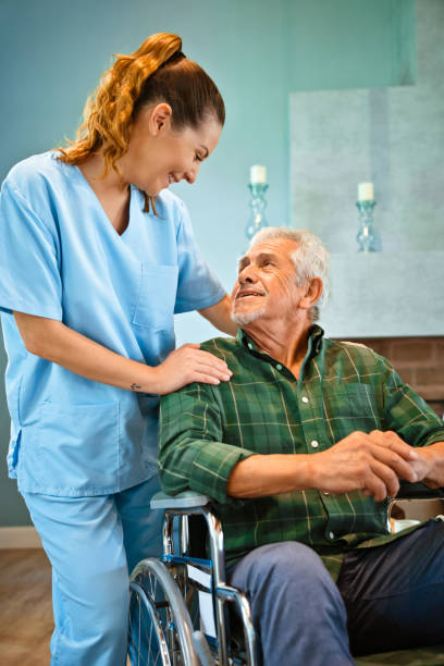 istock Female nurse standing by disabled senior man 1167539402