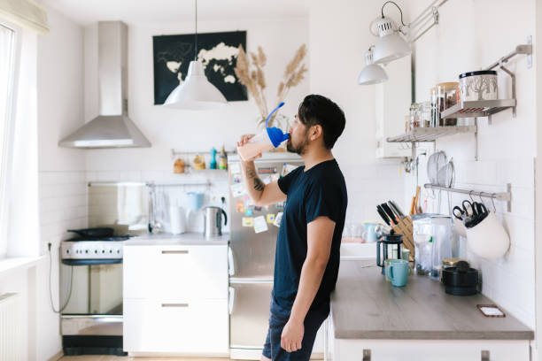 Asian fitness vlogger drinks protein shake after home workout