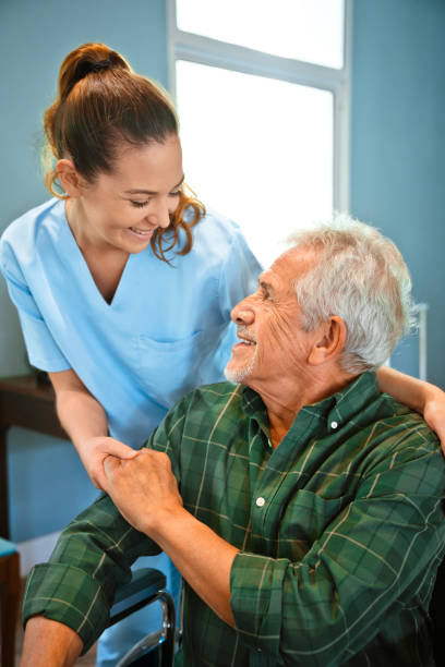 istock Smiling nurse holding hands of disabled man 1167540978