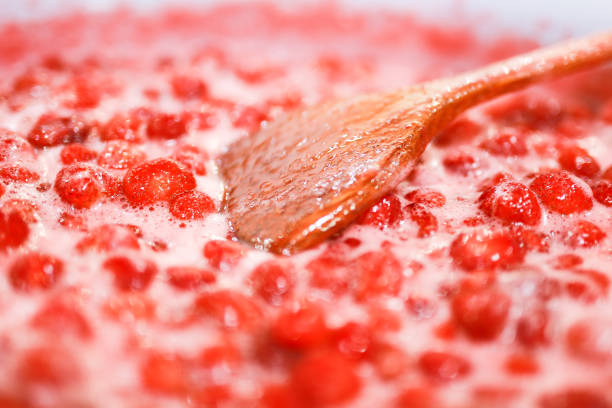 istock Strawberry jam cooking process. Wooden spoon liying on jam surface. Organic traditional jam manufacturing. 1167542392