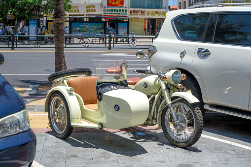 Hainan, Sanya, China - May 18, 2019: Rare motorcycle with a stroller with a BMW logo is parked near the market in the Chinese city of Sanya.