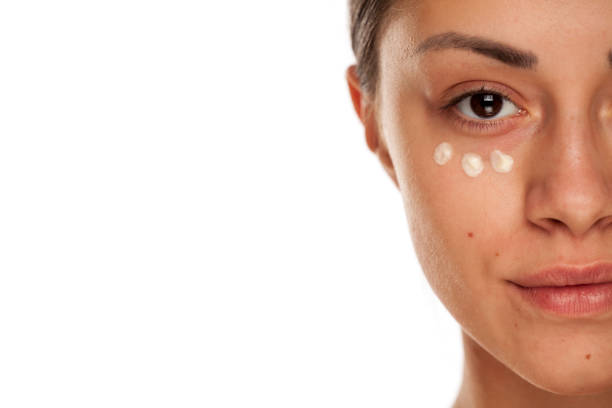 istock beautiful young woman with moisturizer on her face on white background 1167544599
