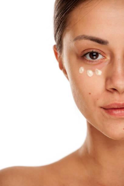istock beautiful young woman with moisturizer on her face on white background 1167544624