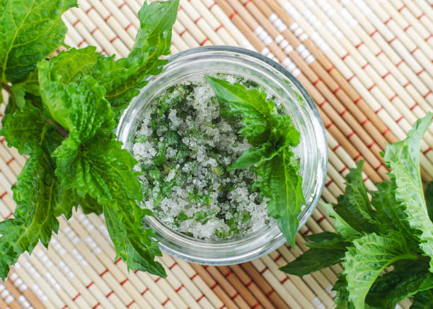 Homemade mint exfoliating scrub (foot soak, bath salt) with sugar, chopped mint leaves, olive oil end essential mint oil. Natural skin and hair care. DIY beauty treatments, spa recipe. Copy space. exfoliante casero de menta (remojo de pies, sal de baño) con azúcar, hojas de menta picadas, aceite de oliva extremo aceite de menta esencial. cuidado natural de la piel y el cabello. tratamientos de belleza diy, receta de spa. copiar espacio.