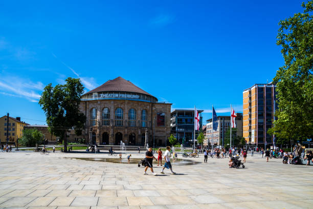 Freiburg im Breisgau, Germany, August 8, 2019, Many people enjoying hot sunny summer day relaxing at old synagogue square in downtown city of freiburg stock photo