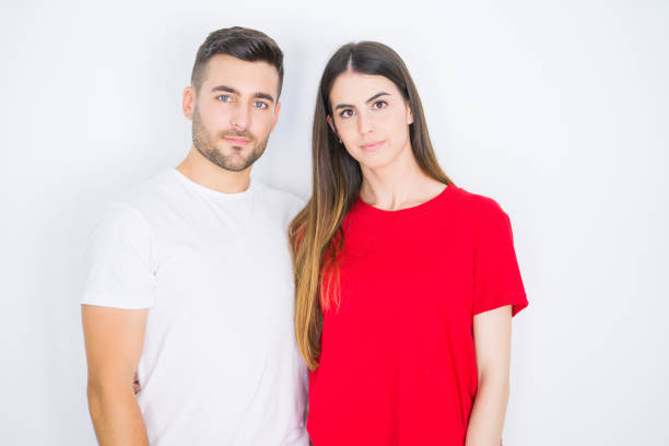 istock Young beautiful couple together over white isolated background with serious expression on face. Simple and natural looking at the camera. 1167545749