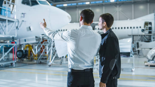 istock Aircraft Maintenance Worker and Engineer Having Conversation. Looking at the airplane. 1167549596