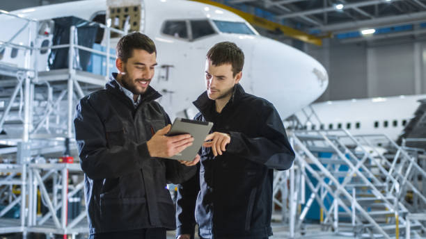 istock Aircraft Maintenance Worker and Engineer having Conversation. Holding Tablet. 1167549616