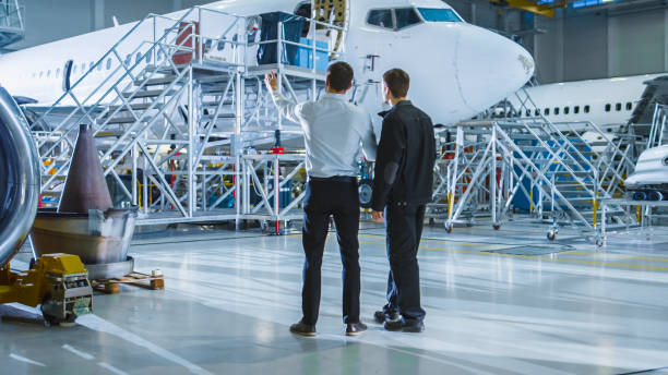 istock Aircraft Maintenance Worker and Engineer Having Conversation. Looking at the airplane. 1167549686