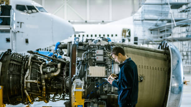 istock Aircraft Maintenance Mechanic Inspecting and using Tablet Airplane Jet Engine in Hangar 1167549687