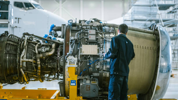istock Aircraft Maintenance Mechanic Inspecting and using Tablet Airplane Jet Engine in Hangar 1167549690