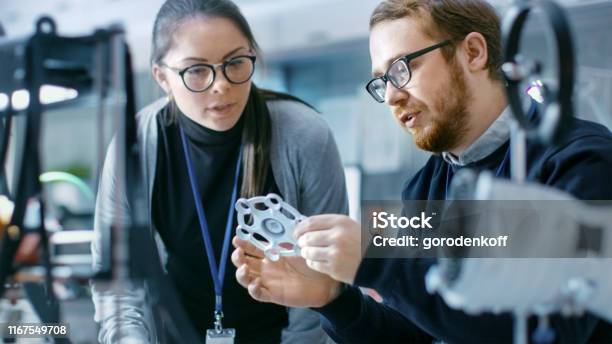 Young Talented Male And Female Engineers In A Modern Laboratory Discussing Prototype Built With The Help Of 3d Printer Stock Photo - Download Image Now