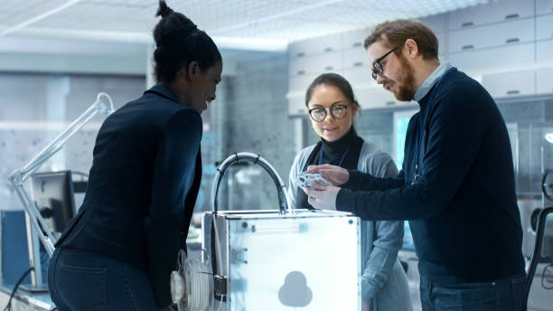istock Three Very Bright and Young Multiethnic Students Discussing 3D Printed Mechanism in a New Modern Laboratory. 1167549761