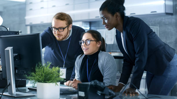 istock Diverse Team of Scientific Engineers Doing Research on a Computer in a high Tech Laboratory on a High Profile Start-up. Team Consists of Black and Caucasian Young Women and White Male. 1167549770
