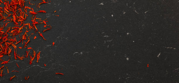 istock Top down view, orange / red dried saffron spice on black board. 1167550352