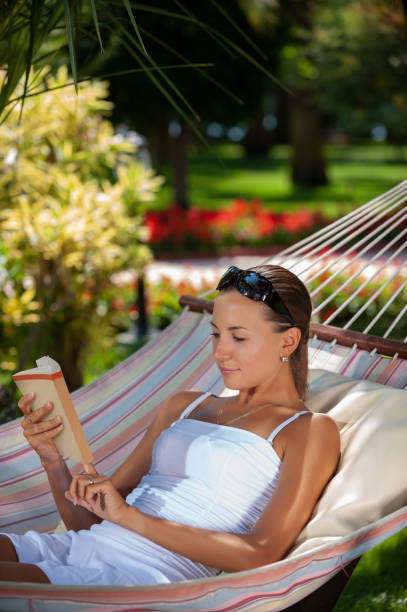istock Reading a book on hammock in a peaceful garden during holiday 1167551205