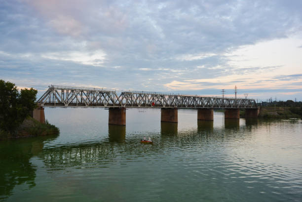 istock The gray Samara railway bridge over the surface of the Samara river with a beautiful landscape, green trees, bushes and greenery. Pictures of the river landscape with an unusual sky and bright clouds. Dnipro, Ukraine. 1167551911