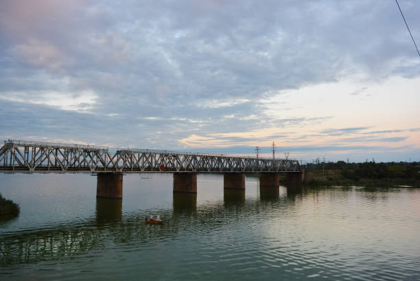 istock The gray Samara railway bridge over the surface of the Samara river with a beautiful landscape, green trees, bushes and greenery. Pictures of the river landscape with an unusual sky and bright clouds. Dnipro, Ukraine. 1167551921