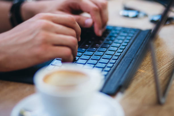 Man working online at a cafe Young caucasian man working online on laptop at a cafe. cpa forum stock pictures, royalty-free photos & images