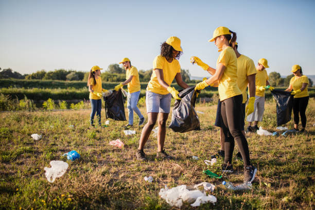 voluntarios juntos recogen basura en el parque - contaminación ambiental fotos fotografías e imágenes de stock