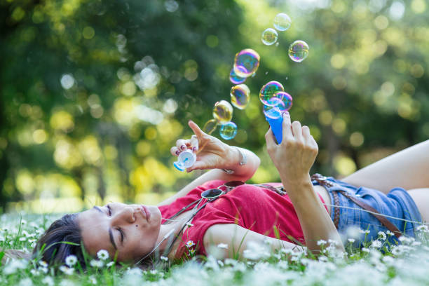 istock Girl blowing soap bubbles in the park 1167553328