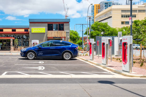 автомобиль tesla model x и нагнетатель tesla - street stall стоковые фото и изображения